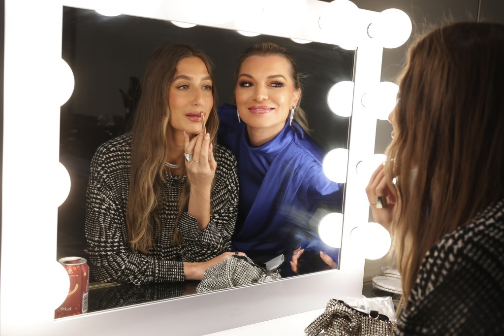 Amanda Batula and Lindsay Hubbard looking in a mirror whole Amanda touches up her makeup