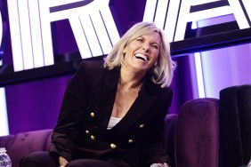 Captain Sandy Yawn in a black suit laughing on stage at BravoCon