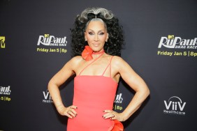 RuPaul's Drag Race judge Michelle Visage in a red dress standing with her hands on her hips