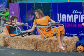 Danielle Fishel in an orange dress, riding on a carnival swing set with her son behind her
